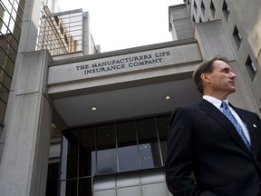 A man is seen outside the Manulife Financial head office in Toronto after their Annual General Meeting on Thursday May 3, 2012. Manulife Financial Corp. says a $2.8-billion post-tax charge related to U.S. tax reform and a decision to change its portfolio asset mix resulted in a $1.6 billion or 83 cents per diluted share net loss in the fourth quarter of 2017.