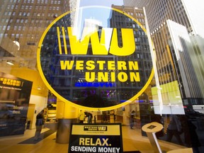 Midtown buildings are reflected in the window of a Western Union store in New York on April 5, 2016. For more than 20 years, Liza Bautista has been sending money home to family in the Philippines, using the same remittance company for much of the time."Because of convenience, and my family over there already knows they're going to be receiving from this institution, I don't shop around any more."