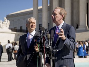 Microsoft President and Chief Legal Officer Brad Smith, right, accompanied by attorney Josh Rosenkranz, left, speaks to reporters outside the Supreme Court, Tuesday, Feb. 27, 2018, in Washington. The Supreme Court heard arguments Tuesday in a dispute between the Trump administration and Microsoft Corp. over a warrant for emails that were sought as part of a drug trafficking investigation.
