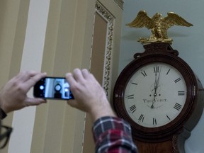 Photographers take a picture of the Ohio Clock shortly after midnight early Friday, Feb. 9, 2018, outside the Senate chamber at the Capitol, in Washington.