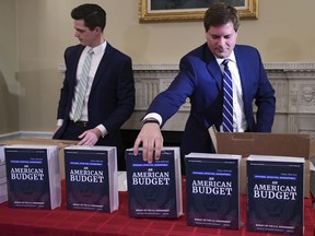 James Knable, left, and Jeffrey Freeland, right, help to unpack copies of the President's FY19 Budget after it arrived at the House Budget Committee office on Capitol Hill in Washington, Monday, Feb. 12, 2018.