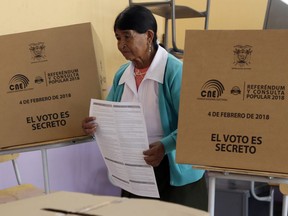 A woman holds her ballot as she votes in a constitutional referendum called by President Lenin Moreno in Quito, Ecuador, Sunday, Feb. 4, 2018. Moreno called for the nationwide referendum that will include a question asking voters whether they want to revoke a law pushed forward by his predecessor allowing presidents to be indefinitely re-elected.