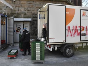 In this Feb. 27, 2018 photo helpers unload a truck of the Essen, western Germany, food bank where unknown people sprayed "Nazis" onto. The food bank was criticized after deciding to only register new users if they prove they've got German citizenship, claiming young foreign men are scaring away elderly people and women.