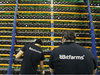 Workers check fans on mining machines at the Bitfarms cryptocurrency farming facility in Farnham, Que.