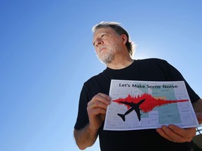 FILE - In this Feb. 6, 2015 file photo, Steve Dreiseszun, a resident of the F.Q. Story historic district in Phoenix, holds a graphic of the increased noise brought on by airplanes flying along new flight paths out of Phoenix Sky Harbor International Airport. More than three years after waking up to find window-rattling flights rerouted over their homes in an airborne highway, residents of Phoenix's historic downtown districts said they finally felt the FAA was listening to them.