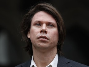 Lauri Love, who is accused of hacking into U.S. government computers, poses for the media outside The Royal Courts of Justice in London, Monday, Feb. 5, 2018. The ruling in Lauri Love's appeal against extradition to the United States, where he faces solitary confinement and a potential 99 year prison sentence, will be handed down on Monday Feb. 5 at the Royal Courts of Justice.