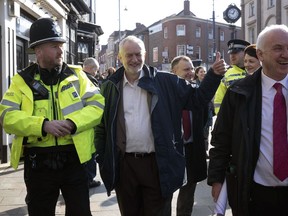 Labour leader Jeremy Corbyn, centre, gives the thumbs up to members of the public during a visit to the town of Stourbridge, England, where he met with police officers from West Midlands Police force, on Saturday Feb. 24, 2018. Britain's main opposition Labour Party leader Jeremy Corbyn will say in a speech Monday Feb. 26, 2018, that the U.K. must retain close economic ties with the European Union after Brexit, including a tariff-free customs deal with the European bloc.