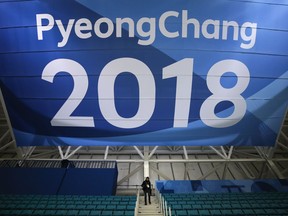 FILE - In this Feb. 6, 2018 file photo, a photographer walks down the steps underneath a large banner at the Gangneung Hockey Center ahead of the 2018 Winter Olympics in Gangneung, South Korea. Fresh off the Super Bowl, NBC begins more than two weeks of Winter Olympics coverage on Thursday, Feb. 8,  with a new host, some new wrinkles and the hope that its business model keeps pace with the different ways people experience events on television and online.