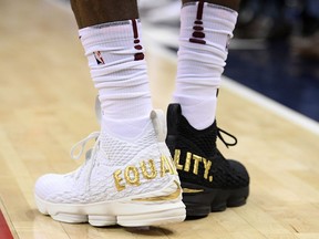 FILE - In this Dec. 17, 2017, file photo, Cleveland Cavaliers forward LeBron James' shoes are emblazoned with "EQUALITY" on both heels during the first half of an NBA basketball game against the Washington Wizards, in Washington. When LeBron James stepped on the court wearing mismatched sneakers in the nation's capital, it wasn't a fashion statement by the NBA's most popular athlete. The message was clearly emblazed in gold on the back of his kicks. Sneaker enthusiasts around the world eagerly await NBA All-Star weekend when new and limited editions of the latest shoes make their debut, but the month leading up to highly anticipated shoe palooza is a time often used to make a social statement.