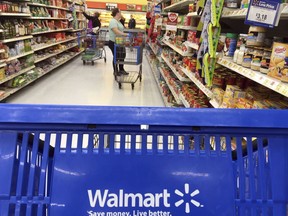 FILE- In this June 5, 2017, file photo, customers shop for food at Walmart in Salem, N.H. Walmart reports financial results Tuesday, Feb. 20, 2018.