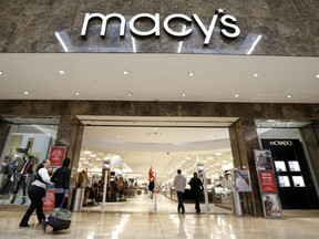 FILE- In this Oct. 25, 2017, file photo, people walk into an entrance to Macy's department store at Garden State Plaza in Paramus, N.J. Macy's Inc. reports financial results on Tuesday, Feb. 27, 2018.