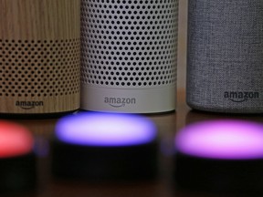 FILE - In this Sept. 27, 2017, file photo, Amazon Echo and Echo Plus devices, behind, sit near illuminated Echo Button devices during an event announcing several new Amazon products by the company in Seattle.  Amazon is expanding its home-security business by buying Ring, the maker of Wi-Fi-connected doorbells. The deal comes months after the online retailer started selling its own Wi-Fi-connected indoor security cameras, which work with its voice-assistant Alexa.