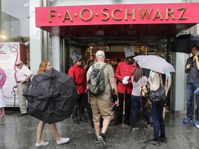 FILE- In this July 15, 2015, file photo, two "toy soldiers" in bright red coats greet customers in front of the flagship FAO Schwarz toy store on Fifth Avenue in New York. FAO Schwarz, whose famous New York store was closed two years ago, said Thursday, Feb. 15, 2018, that it will open locations in Beijing and Shanghai this year through a collaboration with China's largest toy distributor, Kidsland.