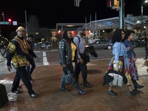 FILE - In this Feb. 15, 2018, file photo, Emanuel Lawton, left, and his family dressed in Wakanda-inspired attire arrive to see Black Panther in Silver Spring, Md. Just as "Black Panther" is setting records at the box office, a new study finds that diverse audiences are driving most of the biggest blockbusters and many of the most-watched hits on television. UCLA's Bunche Center released its fifth annual study on diversity in the entertainment industry Tuesday, Feb. 27, unveiling an analysis of the top 200 theatrical film releases of 2016 and 1,251 broadcast, cable and digital platform TV shows from the 2015-2016 season.
