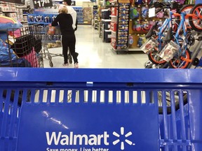 FILE - In this June 5, 2017, file photo, customers shop for food at Walmart in Salem, N.H. Walmart says it will no longer sell firearms and ammunition to people younger than 21. The retailer's new policy comes after Dick's Sporting Goods announced earlier Wednesday, Feb. 28, 2018, that it would restrict the sale of firearms to those under 21 years old. It didn't mention ammunition. Walmart says the decision came after a review of its firearm sales policy in light of the mass shooting at a high school in Parkland, Florida.
