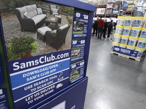FILE- In this June 4, 2015, file photo, a sign encouraging shoppers to use a Sam's Club phone app is displayed at one of the company's stores in Bentonville, Ark. Starting Wednesday, Feb. 14, 2018, the Walmart-owned warehouse club will give free shipping on online orders for Plus members on 95 percent of the items it sells.