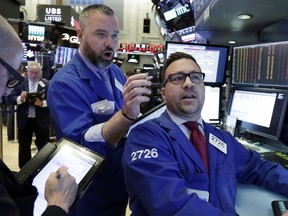 Trader Kevin Lodewick, center, and specialist Paul Cosentino, right, work on the floor of the New York Stock Exchange, Tuesday, Feb. 6, 2018. The Dow Jones industrial average fell as much as 500 points in early trading, bringing the index down 10 percent from the record high it reached on Jan. 26. The DJIA quickly recovered much of that loss.