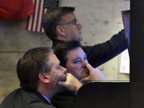 A trio of traders watch their screens in a booth on the floor of the New York Stock Exchange, Monday, Feb. 5, 2018. The Dow Jones industrial average plunged more than 1,100 points Monday as stocks took their worst loss in six and a half years.