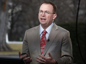 File- This Jan. 22, 2018, file photo shows Director of the Office of Management and Budget Mick Mulvaney talking during a television interview outside the White House in Washington. Mulvaney, the former tea party congressman who runs the White House budget office, said Sunday, Feb. 11, 2018, that Trump's new budget, if implemented, would tame the deficit over time, though unlike last year's submission, it wouldn't promise to balance the federal ledger eventually.