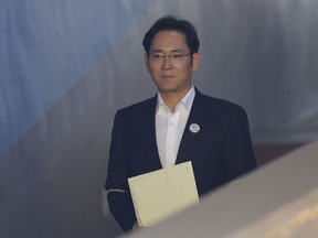 Lee Jae-yong, center, vice chairman of Samsung Electronics, arrives at the Seoul High Court for a hearing in Seoul, South Korea, Monday, Feb. 5, 2018. The court handed down a 2 ½ year suspended jail sentence for corruption to Samsung's billionaire heir Lee. Lee, the only son of Samsung's ailing chairman, was given a five-year prison term in August on bribery and other charges linked to a political scandal that took down former South Korean President Park Geun-hye.
