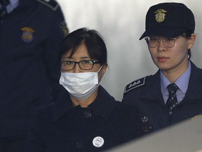 Choi Soon-sil, center, a confidante of former South Korean President Park Geun-hye, arrives at the Seoul Central District Court in Seoul, South Korea, Tuesday, Feb. 13, 2018. Choi Soon-sil, a confidante of former South Korean President Park Guen-hye has arrived at court to hear the verdict in her political corruption case.