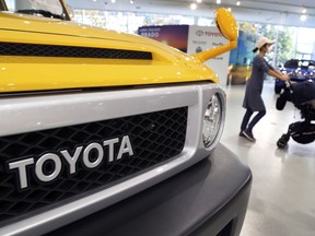 In this Nov. 13, 2017 photo, a visitor walks through at a Toyota showroom in Tokyo. Toyota Motor Corp. reported Tuesday, Feb. 6, 2018 an October-December profit of 941.8 billion yen ($8.6 billion), up from 486.5 billion yen the same period the previous year.