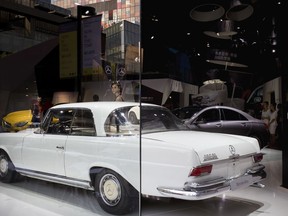 In this Sept. 23, 2015, photo, models pose next to Mercedes-Benz car models on display during a promotional event at a shopping mall in Beijing. Mercedes-Benz issued an apology in China on Tuesday, Feb. 6, 2018 for quoting the Dalai Lama, the Tibetan spiritual leader who is reviled by Beijing, on social media abroad in a reflection of foreign companies' heightened sensitivity to the Communist government's possible reaction to their global activities.