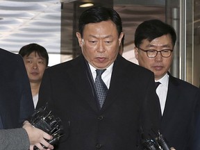 FILE - In this Tuesday, Feb. 13, 2018, file photo, Lotte's Shin Dong-bin, center, a son of Lotte's founder, who was charged with bribery, arrives at the Seoul Central District Court in Seoul, South Korea. Lotte, Asian retail and chewing gum giant, said on Wednesday, Feb. 21, 2018, its holding company's board accepted the resignation of its co-CEO Shin, who has been convicted of bribery and embezzlement. Lotte said that Shin has left his CEO post at Lotte Holdings but will remain on its board as vice chairman.