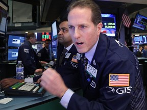 Traders work on the floor of the New York Stock Exchange on Monday when the Dow closed down more than 1,100 points.