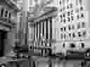 Pedestrians pass in front of the New York Stock Exchange.