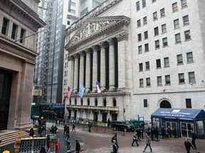 Pedestrians pass in front of the New York Stock Exchange.