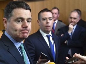 Irish Finance Minister Paschal Donohoe, left, speaks with the media prior to a meeting of the eurogroup at the EU Council building in Brussels on Monday, Feb. 19, 2018. Ireland is withdrawing its candidate, Philip Lane, for European Central Bank vice president, making it almost certain that Spain's finance minister, Luis de Guindos, will get the job.