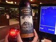 This photo illustration shows a cashier at Jasper Wine Mrkt scanning a B.C. wine bottle with the word discontinued on the screen. The Alberta government announced the boycott of B.C. wines and will stop importing them in the wake of the Trans Mountain pipeline issues.