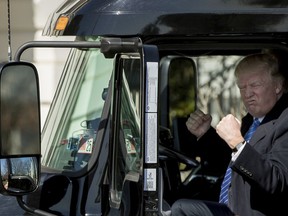 FILE - In this March 23, 2017, file photo, President Donald Trump gestures while sitting in an 18-wheeler truck while meeting with truckers and CEOs regarding healthcare on the South Lawn of the White House in Washington. President Donald Trump is putting the brakes on attempts to address dangerous transportation safety problems from speeding tractor-trailers to sleepy railroad engineers as part of his quest to roll back regulations across the government.1