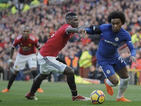 Chelsea's Willian, right, challenges for the ball with Manchester United's Paul Pogba during the English Premier League soccer match between Manchester United and Chelsea at the Old Trafford stadium in Manchester, England, Sunday, Feb. 25, 2018.