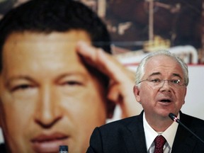 FILE - In this Jan. 29, 2013 file photo, Venezuela's Oil Minister Rafael Ramirez attends a signing ceremony with the Russian energy company Rosneft in Caracas, Venezuela, in front of a large image of Venezuela's President Hugo Chavez. U.S. prosecutors believe Ramirez received bribes as part of an alleged multibillion-dollar graft scheme in Venezuela's oil industry, an official familiar with the U.S. investigation said Monday, Feb. 12, 2018. Ramirez has called a separate criminal Venezuelan probe retaliation for his decision to break with Venezuela's President Nicolas Maduro, who he has accused of running Venezuela's once-thriving oil industry into the ground and abandoning the socialist ideals of the late Hugo Chavez.