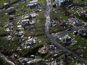 FILE - In this Sept. 28, 2017 file photo, destroyed communities are seen in the aftermath of Hurricane Maria in Toa Alta, Puerto Rico. Puerto Rico's governor is demanding action, on Tuesday, Feb. 27, 2018, from U.S. Congress after announcing that the Treasury Department has cut a nearly $5 billion disaster relief loan by more than half.