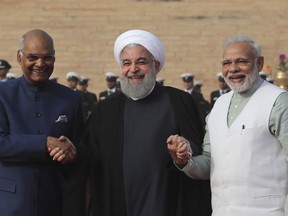 Iranian President Hassan Rouhani, center, holds hands of his Indian counterpart Ram Nath Kovind, left, and Indian Prime Minister Narendra Modi during his ceremonial reception at the Indian presidential palace, in New Delhi, India, Saturday, Feb. 17, 2018. Rouhani, who is on three days state visit to India has strongly criticized the Trump administration's recognition of Jerusalem as Israel's capital and urged Muslims to support the Palestinian cause.