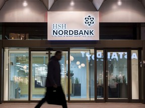 FILE In this Jan. 19, 2018 file photo, a man passes the HSH Nordbank in Hamburg, Germany. Two regional governments in Germany have sold troubled HSH Nordbank to private investors for around 1 billion euros ($1.2 billion). The sale reported Wednesday Feb. 28, 2018  by dpa news agency was required under a deal with European Union competition authorities after the governments of the state of Schleswig-Holstein and the city of Hamburg bailed the bank out and gave state assistance in the form of financial guarantees.