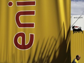 An employee walks by banners with name and sign of energy firm Eni at Strovolos area in capital Nicosia, Cyprus, on Friday, Feb. 23, 2018. Cypriot officials said Turkish warships stopped a renewed attempt by a rig to reach a target southwest of Cyprus where Italian company Eni was scheduled to carry out exploratory drilling for gas. Cyprus' Energy Minister Yiorgos Lakkotrypis said Turkish naval vessels "threatened force" against the rig if it proceeded.