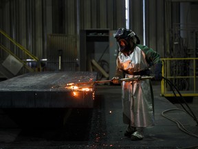 An employee performs a quality check on a steel slab at the Stelco Holdings plant in Nanticoke, Ontario.