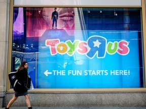 A pedestrian passes in front of a Toys R Us Inc. retail store at Times Square in New York.