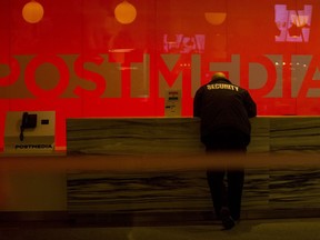 A security guard stands by the front reception desk at Postmedia's Toronto headquarters on Monday, March 12, 2018. Agents from the Competition Bureau arrived at the newspaper chain's offices to examine the purchase of newspapers in a deal between Postmedia and the Torstar Group in November of 2017.