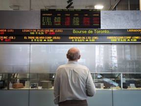 Canada's main stock index edged higher in late-morning trading as the loonie moved up against the U.S. dollar. A man watches the financial numbers at the TMX Group in Toronto's financial district in a May 9, 2014 photo.