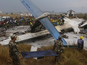 Nepalese rescuers work after a passenger plane from Bangladesh crashed at the airport in Kathmandu, Nepal, Monday, March 12, 2018. The passenger plane carrying 71 people from Bangladesh crashed and burst into flames as it landed Monday in Kathmandu, Nepal's capital, killing dozens of people, officials said.