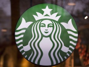 A Starbucks sign is pictured in downtown Vancouver, B.C. Friday, March 20, 2015. Starbucks Corp. is vowing to end pay disparities for workers at its Canadian stores that identify as female or as a minority, after achieving parity in the U.S.