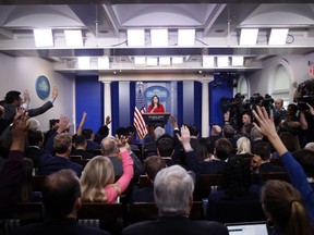 Reporters raise their hands to ask a question of White House press secretary Sarah Huckabee Sanders during the daily press briefing at the White House, Wednesday, March 28, 2018, in Washington.