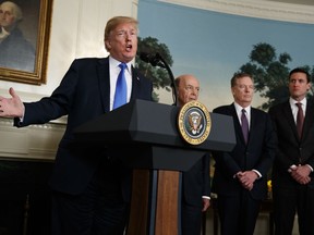 President Donald Trump speaks before he signs a presidential memorandum imposing tariffs and investment restrictions on China in the Diplomatic Reception Room of the White House, Thursday, March 22, 2018, in Washington. Secretary of Commerce Wilbur Ross, United States Trade Representative Robert Lighthizer, and White House homeland security adviser Tom Bossert listen.