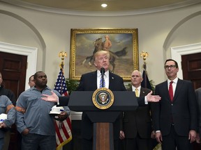President Donald Trump, center, speaks in the Roosevelt Room of the White House in Washington, Thursday, March 8, 2018, before signing two proclamations, one on steel imports and one on aluminum imports. Standing with Trump are workers, left, Vice President Mike Pence, Treasury Secretary Steven Mnuchin and Commerce Secretary Wilbur Ross.