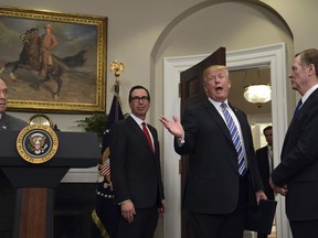 President Donald Trump, second from right, makes a comment as he leaves the Roosevelt Room at the White House in Washington, Thursday, March 8, 2018, following an event where he signed two proclamations, one on steel imports and the other on aluminum imports. Watching as Trump leaves are, from left, Commerce Secretary Wilbur Ross, Treasury Secretary Steven Mnuchin, and U.S. Trade Representative Robert Lighthizer.